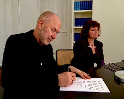 Unterzeichnung des Kaufvertrags durch Fr. Griasch und Hr. Grünenwald